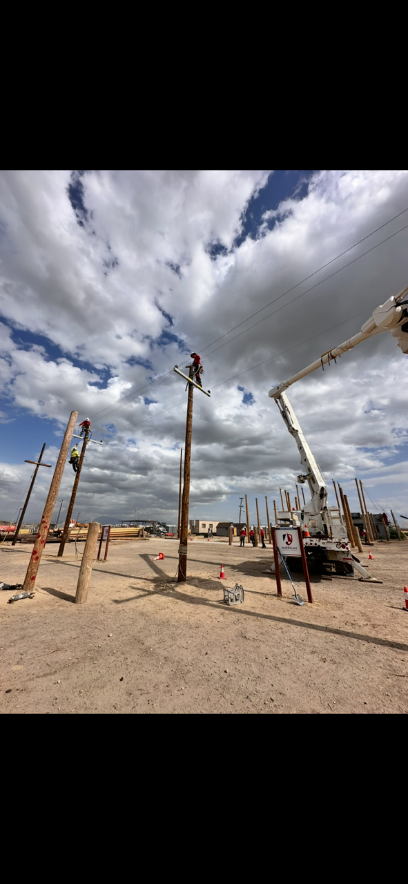 Multiple trainees on poles and a bucket truck in the training yard